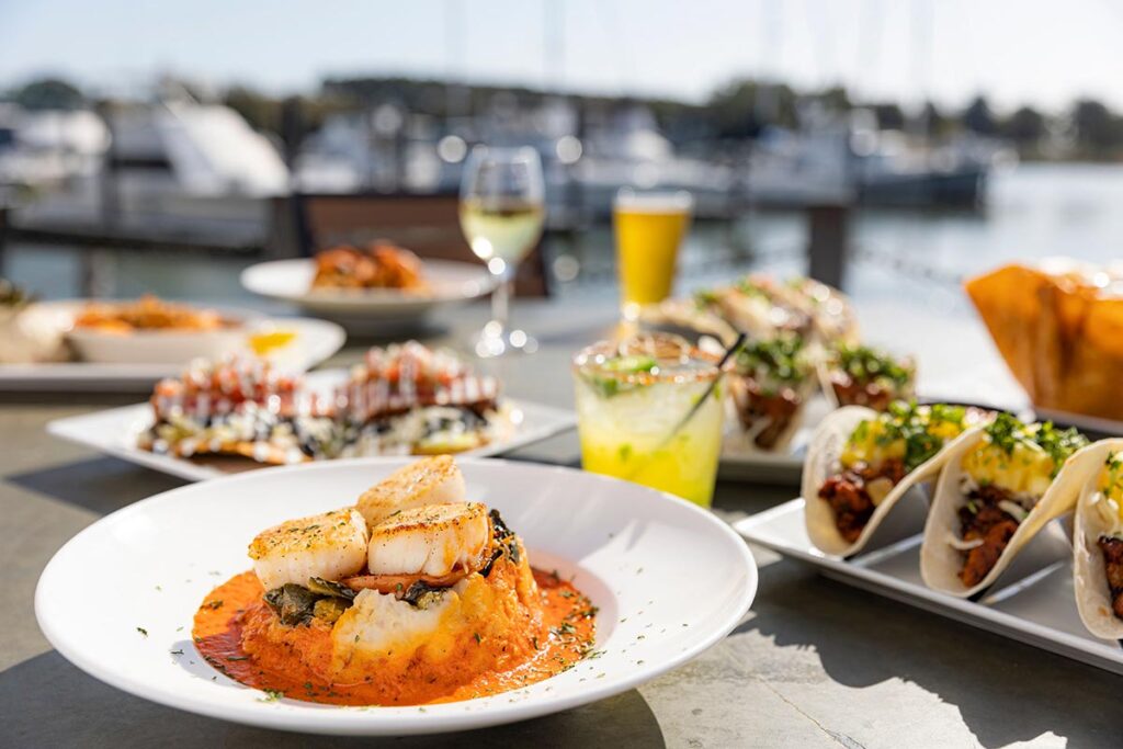Seared scallops on mashed potatoes with drinks and tacos by the marina